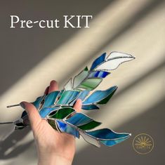 a hand holding a piece of stained glass with the words precut kit on it