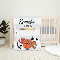 a baby crib with a personalized blanket and sports themed bedding in it