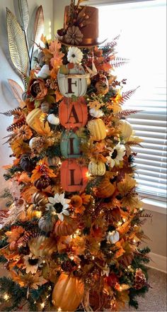 a decorated christmas tree with pumpkins and other holiday decorations in the shape of letters