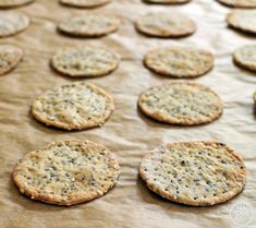 several crackers sitting on top of a table covered in wax paper and sprinkled with black pepper