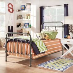 a bedroom with a metal bed frame and blue curtains on the window sill above it