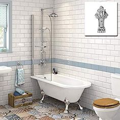 a white bath tub sitting next to a toilet in a bathroom with blue and white tiles on the floor