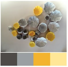 several different shades of gray and yellow are arranged in the shape of flowers on a white surface