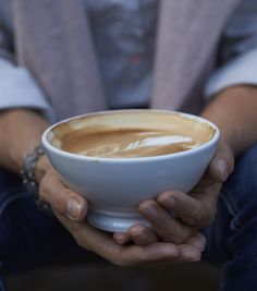 a person holding a cup of coffee in their hands