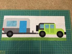 a piece of fabric with a green truck on it and a blue door in the background