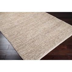 an area rug with wooden floors and dark wood flooring in the background, there is a