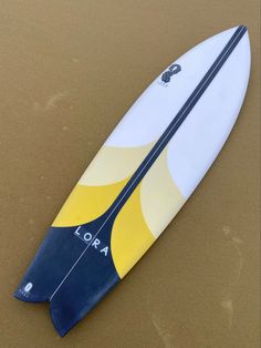 a surfboard laying on top of a sandy beach