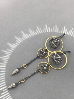 three black and gold earrings on a silver background