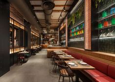 a restaurant with long tables and red booths