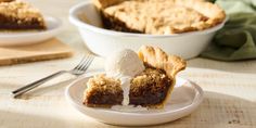 a slice of pie on a plate with ice cream and fork next to the pie