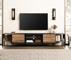 a large flat screen tv mounted to the side of a wooden entertainment center in a living room