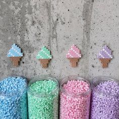 five plastic containers filled with different colored candies next to each other on a wall