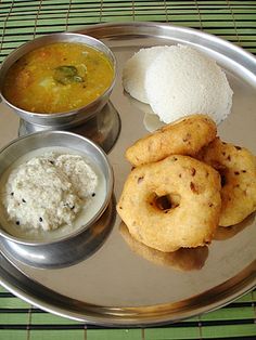 a silver plate topped with different types of food and dipping sauces on top of it