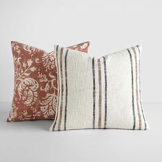 two brown and white pillows sitting next to each other