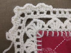 a close up of a piece of cloth with crochet on it and another piece of fabric in the background