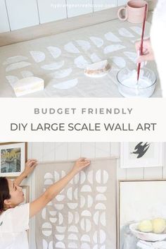 a woman is painting on the wall in her kitchen with white paint and stencils