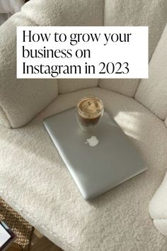 a laptop computer sitting on top of a white couch next to a cup of coffee