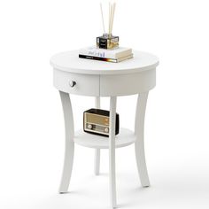 a small white table with a radio on top and some books sitting on the shelf