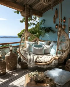 a porch with a swing chair and pillows on it