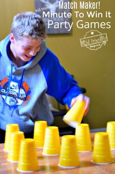 a boy is playing with yellow cups on the table and has his hands in them