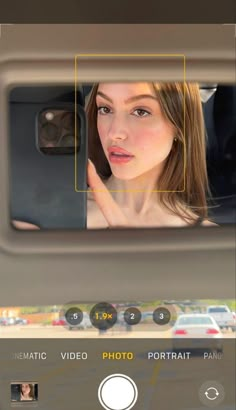 a woman is seen through the rear view mirror