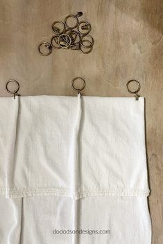 a pair of scissors hanging on the side of a piece of white linen with metal handles