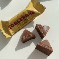 three pieces of chocolate candy sitting next to each other on a white counter top,