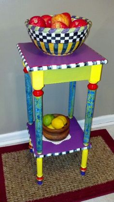 a colorful table with a bowl of fruit on top