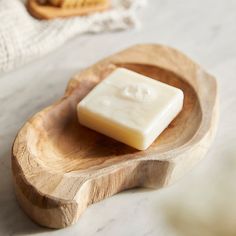 a bar of soap sitting on top of a wooden bowl