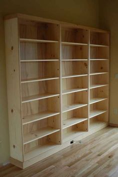 empty bookshelves in an empty room with hard wood flooring and bare walls