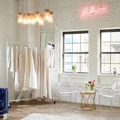 a white room with clothes hanging on the wall and a table in front of it