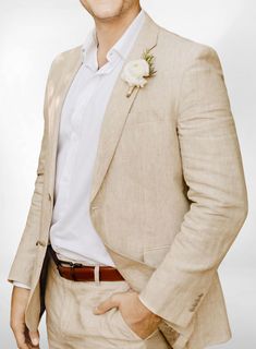 a man in a tan suit with a flower on his lapel