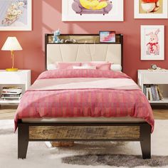 a bedroom with pink walls and pictures on the wall above the bed, along with an upholstered headboard