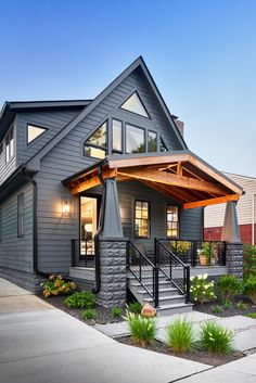 a gray house with a covered porch and wooden steps leading up to the front door