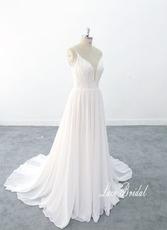 a white wedding dress on a mannequin in front of a white wall and floor