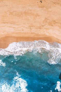 an aerial view of the ocean and sandy beach