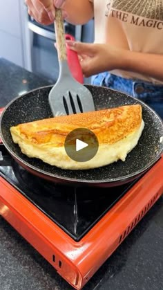 a person is cooking omelets on top of an orange toaster with a spatula