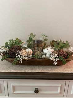 a tray with flowers and candles on top of a counter