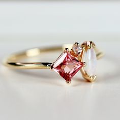 This beautiful, handmade unique cluster ring was made of 14k gold band, 14k gold prong settings. It's perfect as engagement ring or family birthstone statement piece. DETAILS ABOUT THE RING, MATERIAL AND STONES * 14k 1.3mm solid gold band and prongs. * 4x4mm princess cut natural pink tourmaline center stone * 6x3mm marquise cut real Australian opal * 1.5mm natural diamond ( 0.015 ct. weight) GH color SI clarity This ring can be personalized with the different birtstones. RING SIZE : US 7 READY TO SHIP! It can be resized in a week. ** All our raw materials are sourced from US-based companies for the quality and safety of our handmade products. *** This ring is handcrafted for you in our local studio in Redlands, California. We are a small workshop which specializes on handmade jewelry. *** Opal And Tourmaline Ring, Opal And Pink Tourmaline Ring, Senior Ring, Senior Rings, Pink Tourmaline Engagement Ring, Redlands California, Pink Tourmaline Ring, Small Workshop, Solid Gold Band