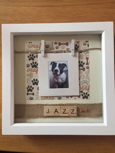 a frame with a dog's name and paw prints on it