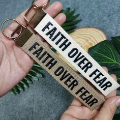 a hand holding a keychain that says, father over fear