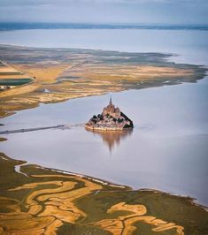 an island in the middle of a large body of water surrounded by land and trees