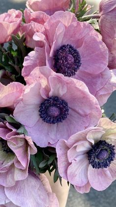 pink flowers are in a white vase on the ground