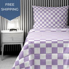 a purple and white checkered comforter on a bed in a room with two nightstands