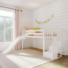 a white bunk bed with a slide and pillows