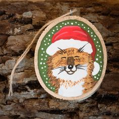 a wooden ornament with a cat wearing a santa hat