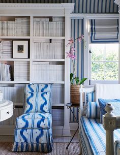 a blue and white chair in front of a bookshelf