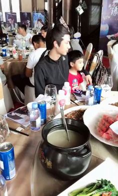 a group of people sitting around a table with food on it