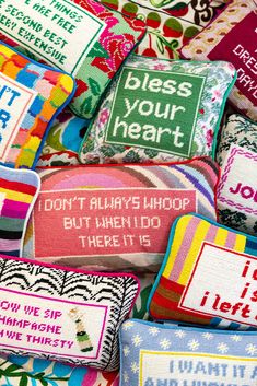 many colorful pillows with different sayings on them