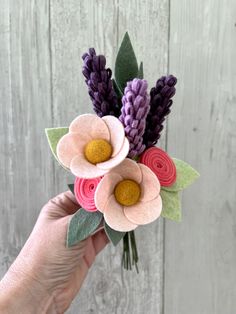 a person is holding some paper flowers in their hand and it looks like they are made out of felt